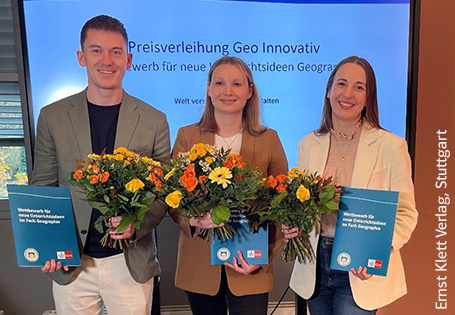 Die drei Preisträgerinnen und Preisträger des Wettbewerbs Geo-Innovativ mit Urkunden und Blumensträußen.