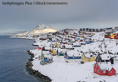 Foto der Hauptstadt Nuuk auf Grönland, bunte Häuser an der Küste und Eisberge im Hintergrund