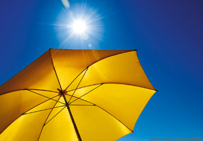 Gelber Sonnenschirm mit blauem Himmel und Sonne